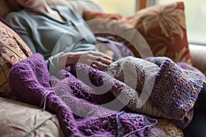 knitter resting with a halffinished purple woolen shawl on their lap