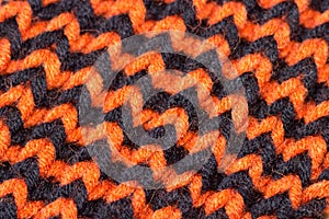 Knitting. Background knitted texture. Bright knitting needles. Orange and black wool yarn for knitting