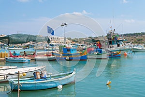 Knitting fishing nets and boats in harbour of Marsaxlokk, Malta