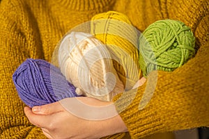 Knitting hobby.Wool yarn in yellow, beige, purple and green.Hobby and needlework.Knitting warm clothes with your own