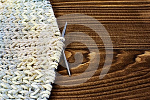 Knitting with knitting needles on wooden background