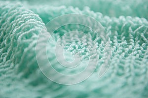 Knitting menthol or green textured wool background, close up of wrinkled fabric