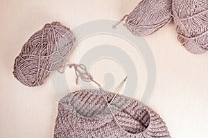 Knitting needles and woolen threads on a wooden background. natural wool knitting background