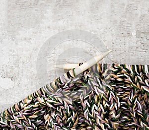 Knitting needles and yarn wooden background