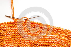 Knitting, orange wool on white