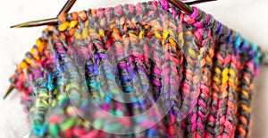 Knitting pattern texture, bright colorful yarn and needles close-up
