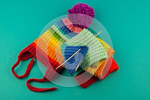 Knitting a rainbow scarf and hat Blue background