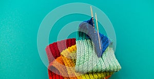 Knitting a rainbow scarf and hat Blue background