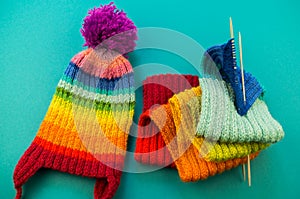 Knitting a rainbow scarf and hat Blue background