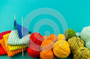 Knitting a rainbow scarf and hat Blue background