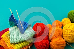 Knitting a rainbow scarf and hat Blue background