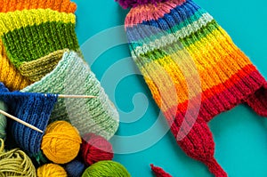 Knitting a rainbow scarf and hat Blue background