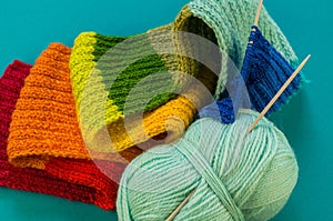 Knitting a rainbow scarf and hat Blue background