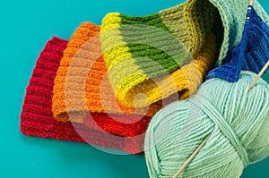 Knitting a rainbow scarf and hat Blue background