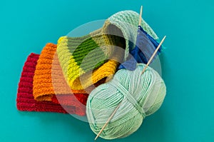 Knitting a rainbow scarf and hat Blue background