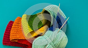 Knitting a rainbow scarf and hat Blue background