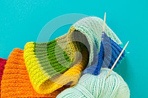 Knitting a rainbow scarf and hat Blue background