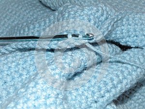 Knitting something with sky blue knitting fabric.