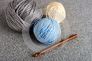 Knitting. wooden crochet hook close-up. Needlework and wool in balls in the background