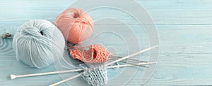 Knitting wool and knitting needles in pastel blue and pink colors