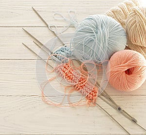 Knitting wool and knitting needles in pastel blue and pink colors