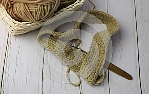 Knitting work with wood crochet hook put beside cotton thread