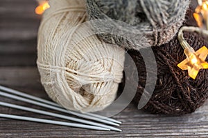 Knitting yarn and needles on wooden background