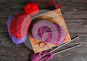 Knitting yarn with needles on wooden table