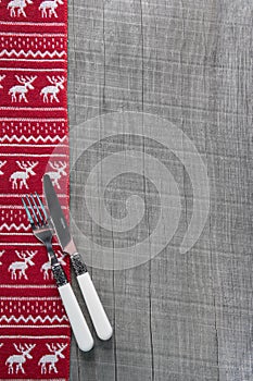 Knives and forks on wooden christmas background in red for a men