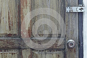 Knob and door hinges on old wooden door