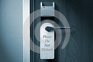 A knob of a hotel door with `Please do not disturb` tag