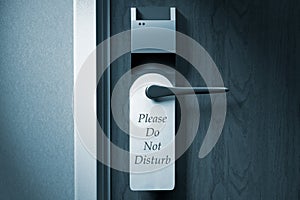 A knob of a hotel door with `Please do not disturb` tag photo