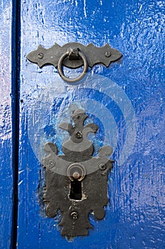 knocker and lock on old blue wooden door, on colonial city of Tiradentes, Minas Gerais state, Brazil