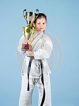 Knockout. energy activity for kids. small girl with champion cup. martial arts. practice Kung Fu. happy childhood. sport