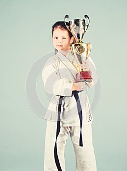 Knockout. energy activity for kids. small girl with champion cup. martial arts. practice Kung Fu. happy childhood. sport