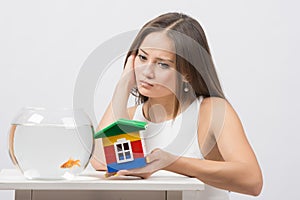 She knocks on the wall of the house a toy aquarium with goldfish