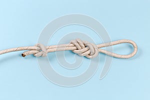 Knot Ð°igure-eight loop with stopper knot on blue background