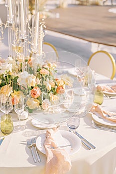 Knotted napkins lie with menus on plates on a festive table