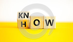 Know how symbol. Businessman turns wooden cubes and changes the word How to Know. Beautiful yellow table white background. Copy