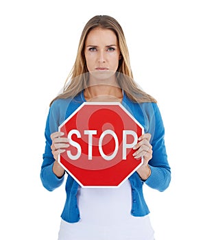 Know what this means. Studio portrait of a stern-looking woman holding a stop sign.