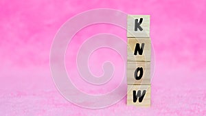 Know writing concept on wooden cube isolated on pink background.