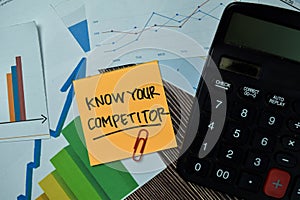 Know Your Competitor write on sticky notes with graphs and diagram isolated on office desk