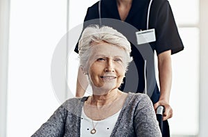 Knowing that theyre cared for feels great. a senior woman in a wheelchair being pushed by a female nurse.