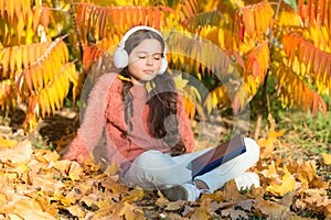 Knowledge assimilate better this way. Small girl enjoy learning online in autumn environment. Little child listening to