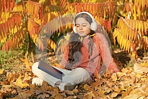 Knowledge assimilate better this way. Small girl enjoy learning online in autumn environment. Little child listening to