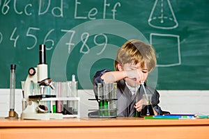 Knowledge concept. Fascinating subject. Knowledge day. Kid study biology chemistry. Boy microscope and test tubes school