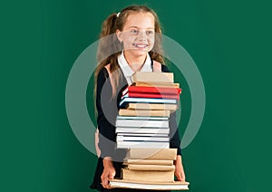 Knowledge day, Smiling little schoolkid girl with backpack hold books on blackboard. Childhood lifestyle concept