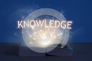 Knowledge inscription. Light coming from open book with word knowledge