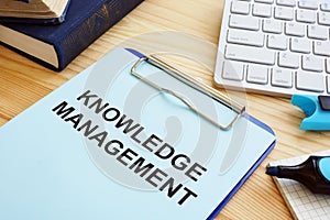 Knowledge management. Clipboard and books on table