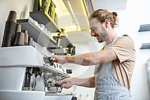 Knowledgeable man cleaning filter of coffee machine